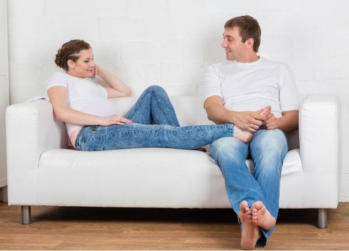 גבר עושה עיסוי רגליים לאישה בשבוע 30 להריון הסובלת מכאבים ובצקות ברגליים