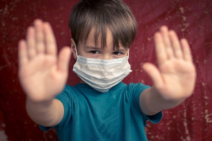 ילד חובש על פניו מסכה למניעת הדבקה ב-COVID 19