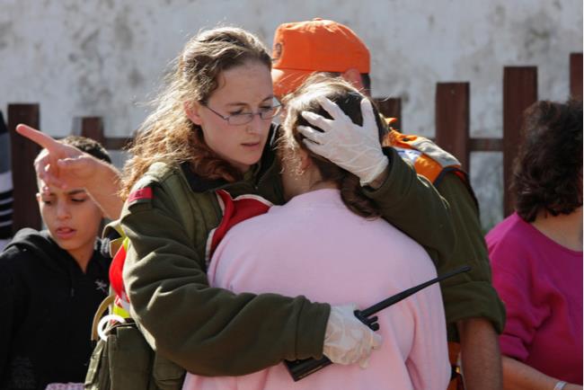 חיילת מחבקת נערה בפוסט טראומה אחרי התקפת טילים
